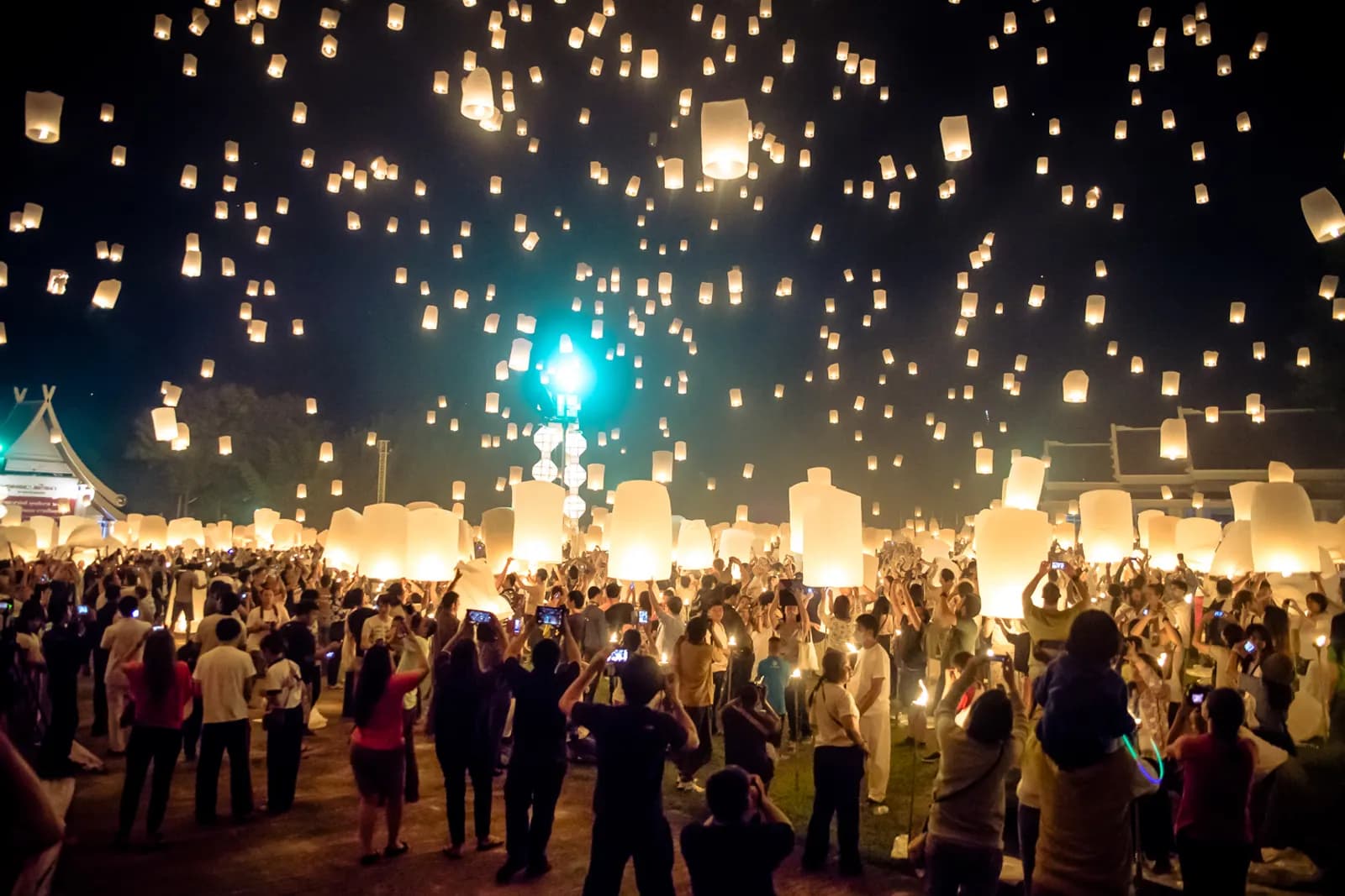 Hundreds of sky lanterns rising over the crowd at a Yi Peng lantern release in San Sai, just outside Chiang Mai