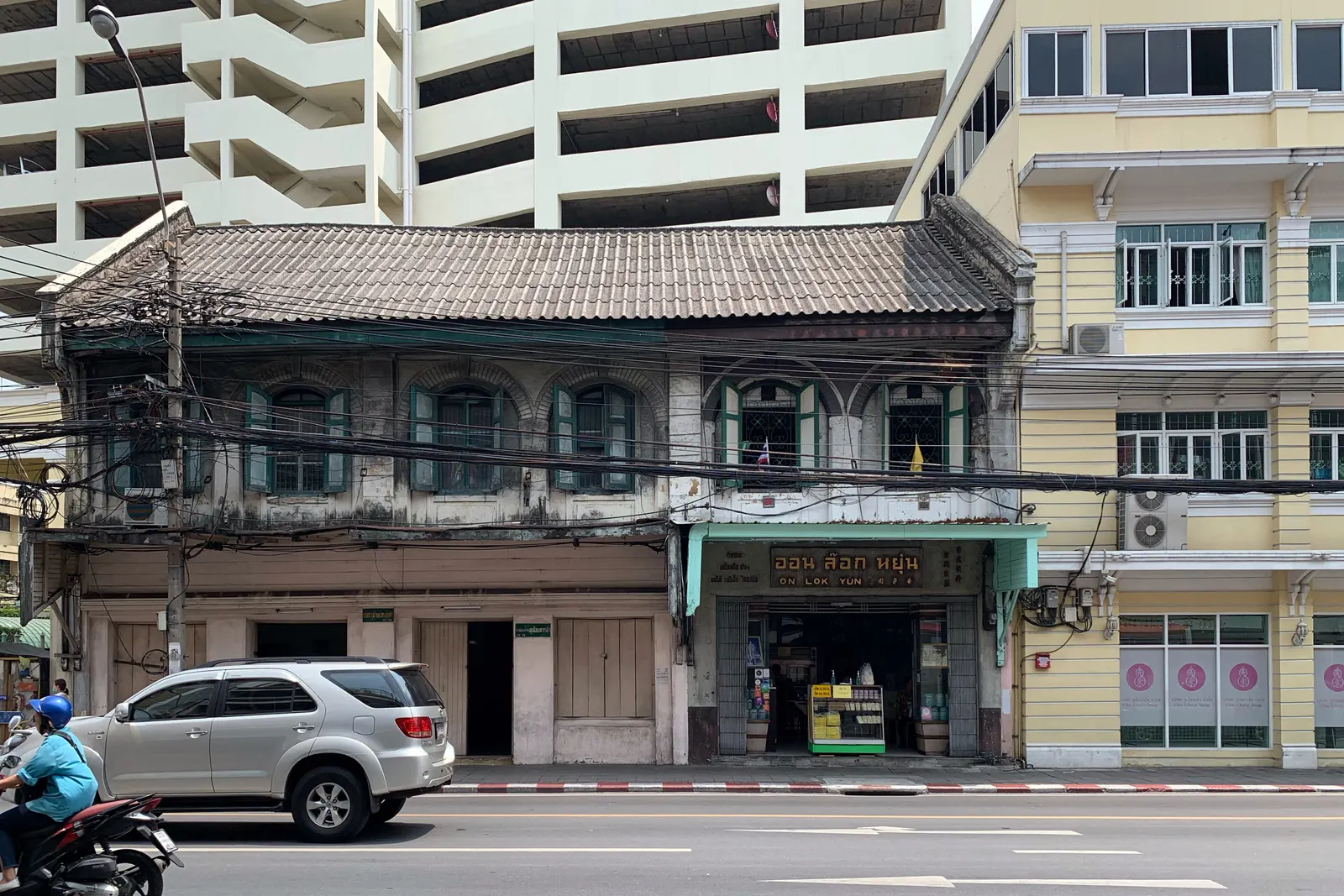 Charoen Krung 路上安乐园的两层老店屋,门头挂着泰文和英文招牌