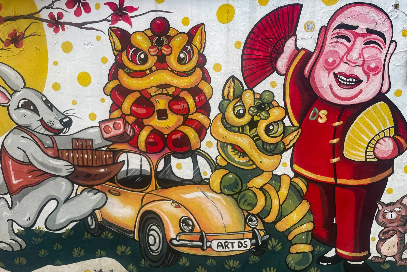 A mural of lion dancers and a yellow car on a wall in Talat Noi, Bangkok