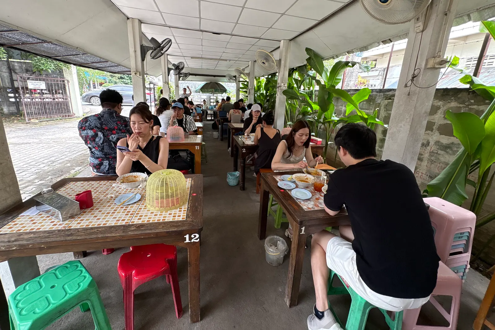 Lunchtime diners at the open-sided tables of Khao Soi Khun Yai in Chiang Mai's Old City