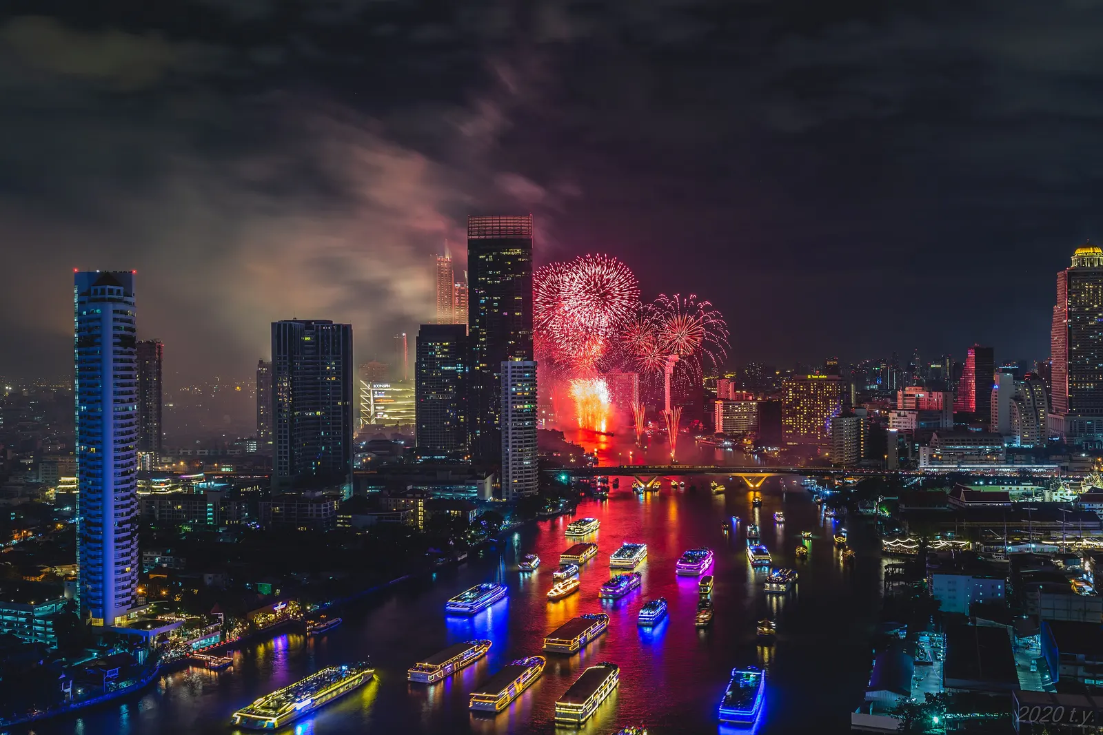 2020年1月1日零点刚过，从河边高楼往下看湄南河上的跨年烟花，河面的游船都亮着灯