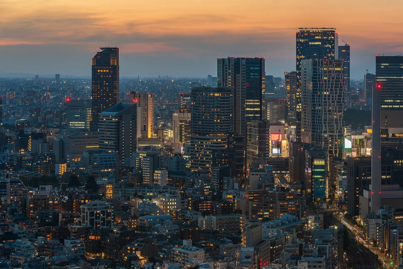 Shibuya's towers lit up at dusk, seen from Ebisu in Tokyo
